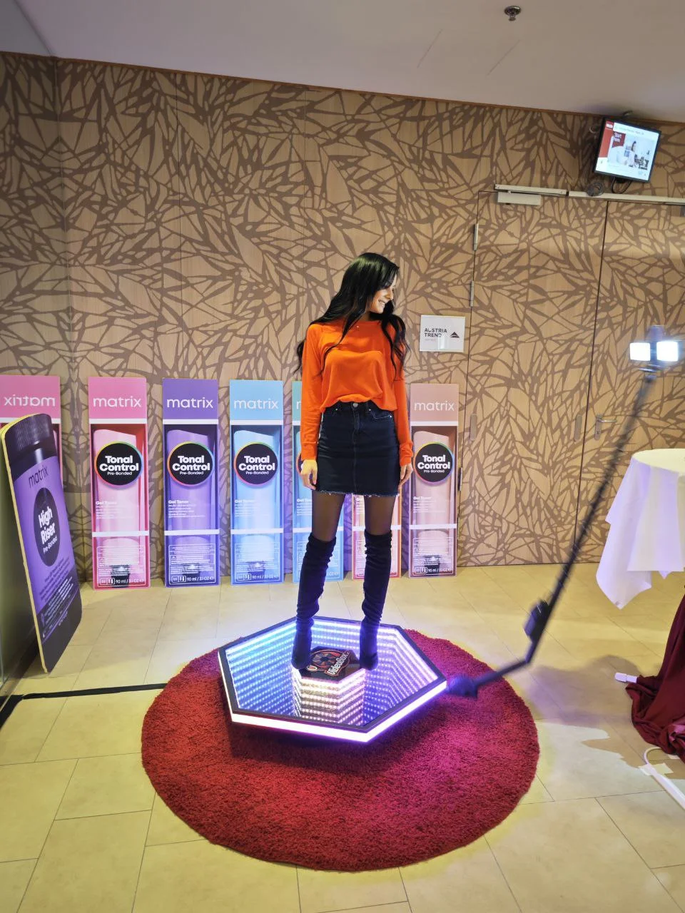 Gast auf der 360°-Videobox vor einer Event-Fotowand